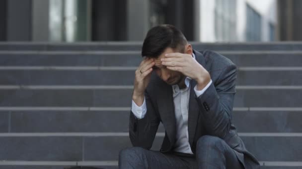 Despedido hombre barbudo europeo infeliz perder el trabajo sentado en las escaleras. Joven empresario trastornado en la frustración fuera del departamento de oficina. Desempleo. Crisis. — Vídeos de Stock