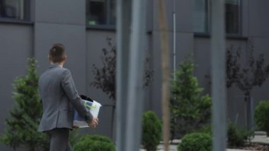 Heyecanlı bir erkek stajyer işteki ilk gününde yeni işyerine bir şeyler taşıyan yeni bir eleman. İş, kariyer ve başarı kavramı
