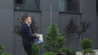 Heyecanlı bir erkek stajyer işteki ilk gününde yeni işyerine bir şeyler taşıyan yeni bir eleman. İş, kariyer ve başarı kavramı.