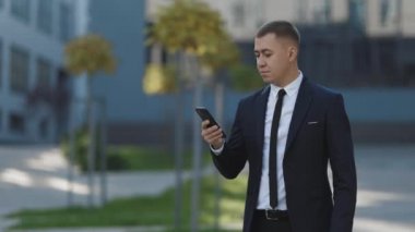 Başarılı iş adamı dışarıda cep telefonuyla zaferi kutluyor. Dışarıdaki cep telefonuna şaşırmış bir adam. Akıllı telefondan iyi haberler okuyan heyecanlı bir adamın portresi..