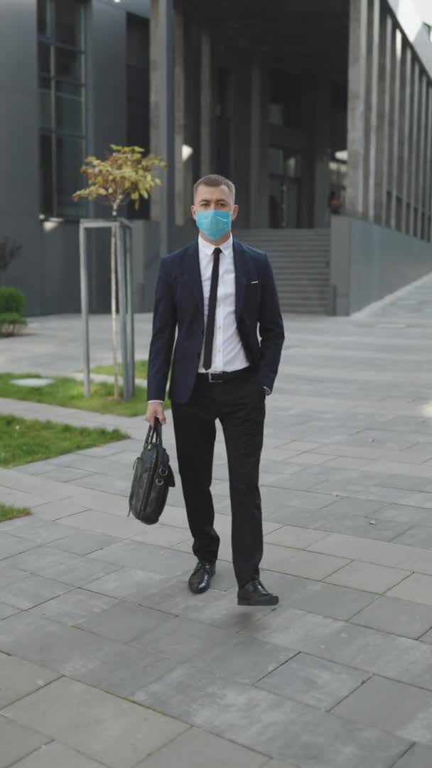 Hombre de negocios retrato en máscara facial protectora Mira la cámara COVID-19 Infección por Coronavirus. Máscara facial Covid-19. Epidemic Coronavirus Mers. Human Masked 2019-ncov. Video con pantalla vertical. — Vídeos de Stock