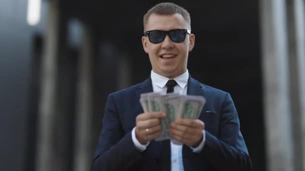 Hombre de negocios exitoso contando dinero. Hombre sonriente disfrutar de un buen trato cerca de la oficina moderna. El hombre hizo dinero fácil. Hombre rico en traje elegante con gafas de sol contando dinero. — Vídeos de Stock