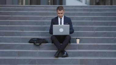 Takım elbiseli bir girişimci internette iş aramak için dizüstü bilgisayar kullanıyor. 2020 Krizi. Coronavirüs salgını. Sorun çözüldü. İşadamı Laptop 'ta çalışıyor..