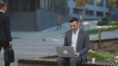 Şehirdeki genç işadamı bankta oturur, bir dizüstü bilgisayar alır ve çalışır. Dışarıda dizüstü bilgisayarda daktilo yazan bir iş adamı. Takım elbiseli adam bankta otururken dizüstü bilgisayarla çalışıyor. Uzak çalışma konsepti