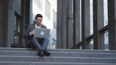 Takım elbise giyen kendine güvenen işadamı web kamerası görüntülü internet yayını eğitimi için konferans çağrısı yapıyor. İş adamı video konferansında konuşuyor. Şehir caddesinde video konferansı.