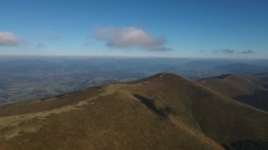 Yazın parlayan güneşle ormanın ve dağ vadisinin yukarısına taşınmak. Açık yeşil doğa manzaralı dağlar. Hava görüntüsü 4k İHA uçuşu.