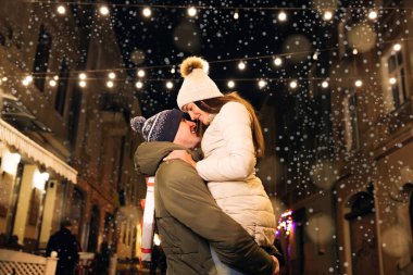 Noel hediyesi değişimi. Xmas birlikte kutluyor. Gülümseyen bir çift Noel arifesini parlak bir çelenkle kutluyor..
