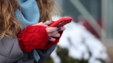 Yeni yılda, kış şehrinde sokakta dururken akıllı telefondan mesaj atan kadın ellerini kapat. Dışarıdaki cep telefonuna dokunan kadın parmakları. Modern tatiller online alışveriş, yeni yıl hediyeleri almak.