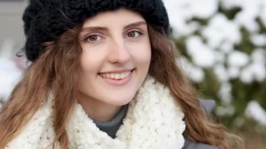 Kameraya bakan güzel, kıvırcık, beyaz, güzel ve zarif genç bir kadının yakın plan portresi. Kariyer insanları. Fshion kızı kış caddesinde duruyor. Kadın portreleri.