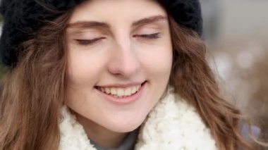 Yüzünü kapat, siyah şapkalı kıvırcık kadın gözlerini aç, gülümse ve kameraya bak. Caddede Witer 'da duran mutlu kızın portresi. İnsanlar ve duygular kavramı