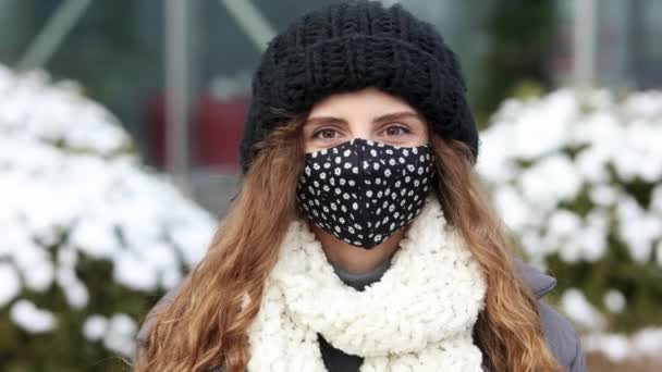 Tıbbi maskeli genç bir kadın şehre karşı duruyor. SARS-CoV-2 virüsünü yaymak için maske takan bir şehirde COVID-19 Pandemic Coronavirus Woman. Yavaş çekim 4k. — Stok video