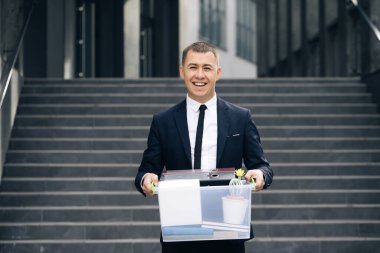 Bir kutu kişisel eşyası olan portre erkek ofis çalışanı. İş adamı işini kaybetti. Dışarıdaki adam. İşsiz biri. İşsizlik kavramı. Parasız kaldı.