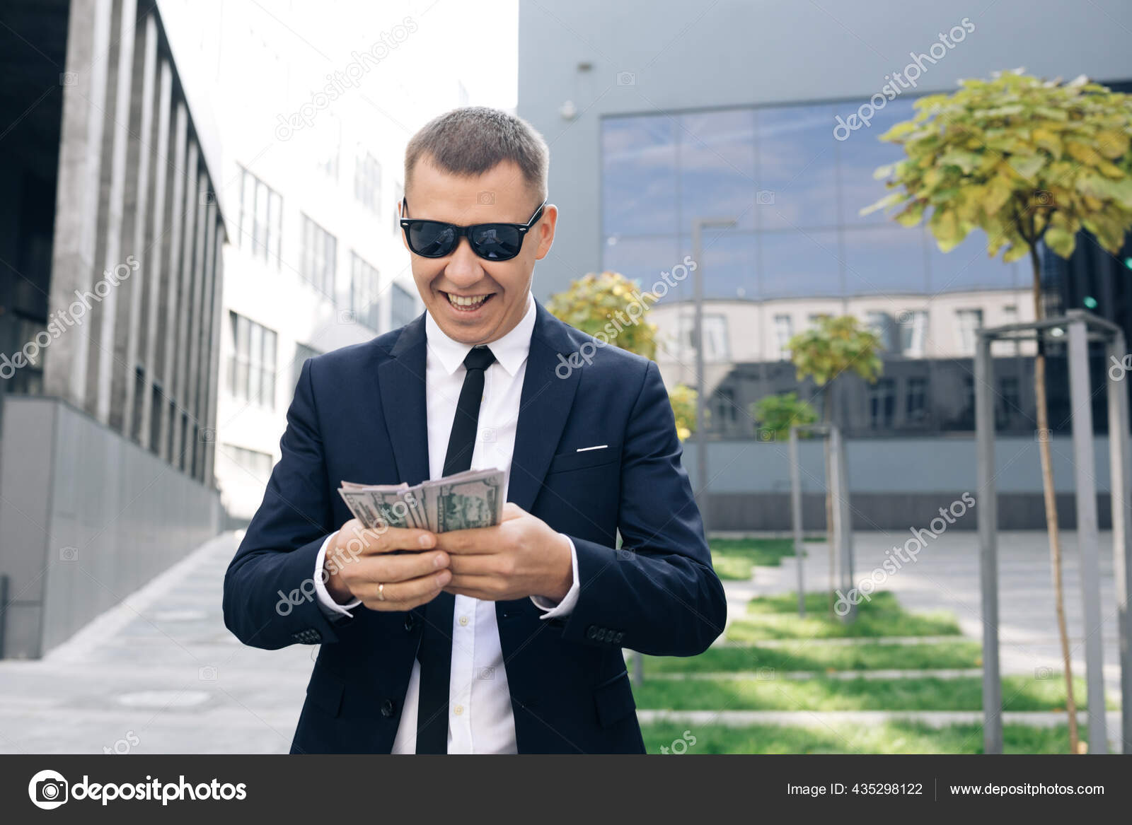 Rik mann i stilig dress, med solbriller, som teller penger og går nær  kontorbygg. Ser vellykket ut, selvsikker – stockfoto © uflypro #435298122, image size:1600x1167