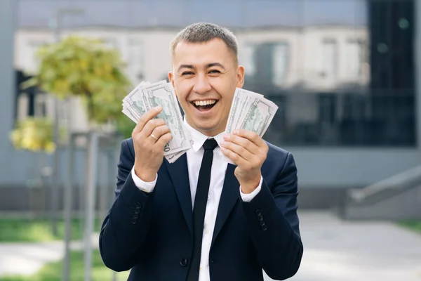 Heureux homme d'affaires enthousiaste avec de l'argent billets en dollars américains. Symbole de succès, gain, victoire. L'homme montre de l'argent et célèbre — Photo