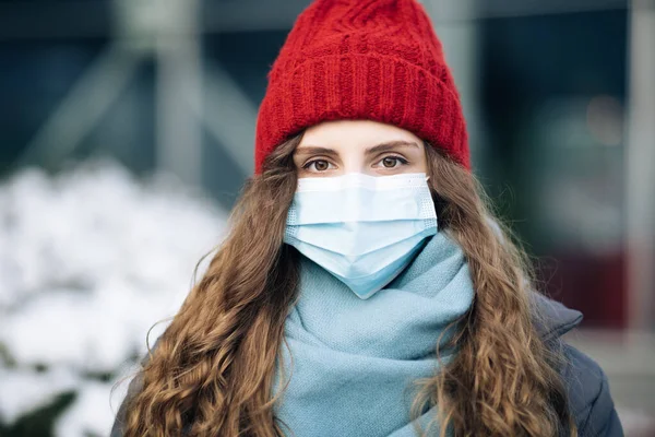 Pandemic coronavirus covid konsep. Wanita berambut cokelat keriting dalam masker pelindung bedah untuk virus korona pencegahan wabah kedua. Gadis dengan topeng pelindung di wajah — Stok Foto
