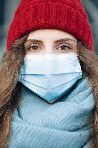Potret perempuan keriting muda Kaukasia dalam topeng medis berdiri di kota musim dingin. Orang-orang sakit covid-19. Epidemic coronavirus. Virus flu korona pandemik — Stok Foto