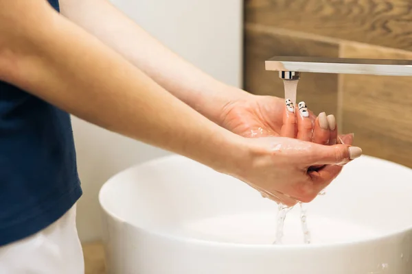 Wash hands with soap warm water rubbing fingers washing frequently or using hand sanitizer gel. Coronavirus pandemic prevention. Hands of woman wash their hands in a sink to wash the skin the hands