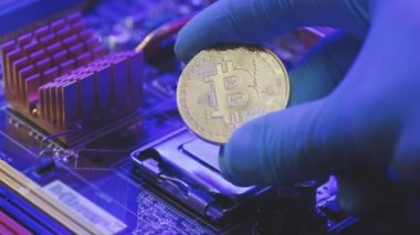 İş adamının elleri anakart arka planında altın Bitcoin taşıyor. Parmaklarda kripto para. İnsan gelecekteki para birimini gösteriyor. Madencilik, ticaret