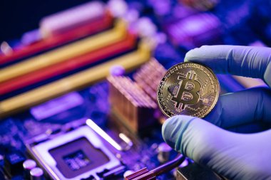 Elleri olan bir işadamı bitcoin tasarımı sunuyor. İş adamı Bitcoin 'i anakart arka planında izole edilmiş halde tutuyor. Dijital Para ve Bitcoine Kavramı