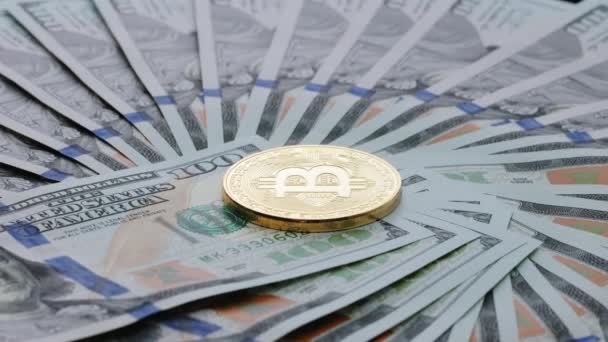 100 dolarlık banknotlarla çevrili Bitcoin şifreli para birimi. 100 dolarlık banknot üzerinde dönen farklı fiziksel metal para birimi. ABD banknotlarıyla dünya çapında sanal internet parası — Stok video
