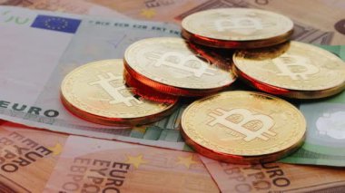 Euro faturaları. Bitcoin 'in kripto para simgesine sahip olan rotasyon madeni para, Avrupa Birliği' nin gerçek banknotları, avro, yeni para, avro, altın para değişimi, yeni ekonomi üzerinde yatmaktadır. Euro banknotları