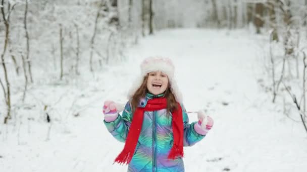 Glückliche Kind Mädchen spielt mit einem Schnee im Winter Tag. Mädchen genießt Winter, frostigen Tag. Spielen mit Schnee in den Winterferien. Spaziergang im Winterwald — Stockvideo