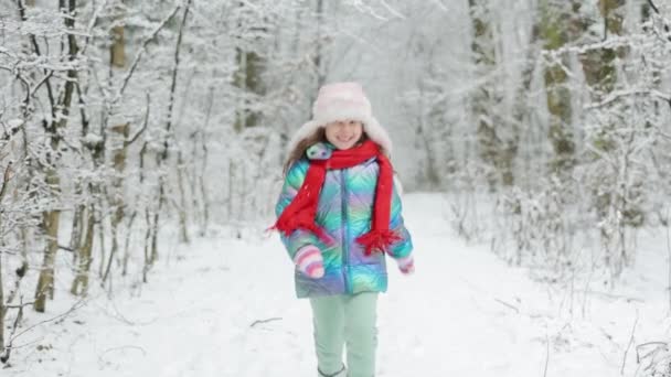 Kleines glückliches Mädchen in Winterkleidung hat Spaß beim Laufen an einem verschneiten Wintertag. Glückliche Kind Mädchen spielt mit einem Schnee im Winter Tag. Mädchen genießt Winter, frostigen Tag — Stockvideo
