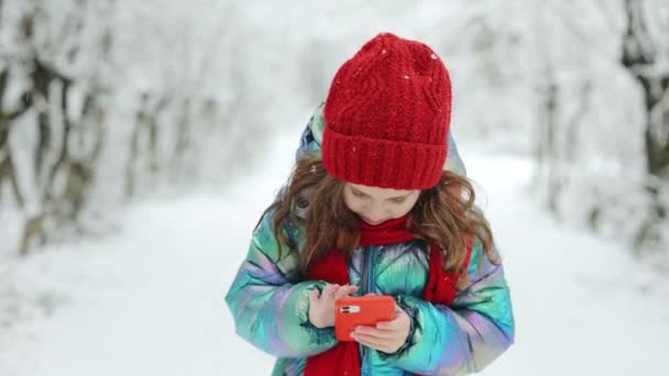 Lächelndes kleines Mädchen mit erhobenem Daumen, isoliert auf winterlichem Hintergrund. Glückliche Kinder und Gesten. Hübsch pre-teen mädchen zeigen daumen nach oben. — Stockvideo