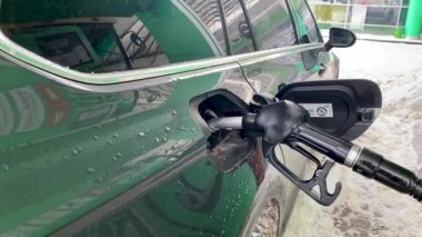 İstasyon pompasında benzinle dolduruyorum. Arabanın deposu yakıt dolu. Diesel Petrol. Benzin deposundaki benzin hortumu. Yakıt başlığı otomobil tankına girdi. Yakıt, benzin istasyonu, benzin fiyatları kavramı