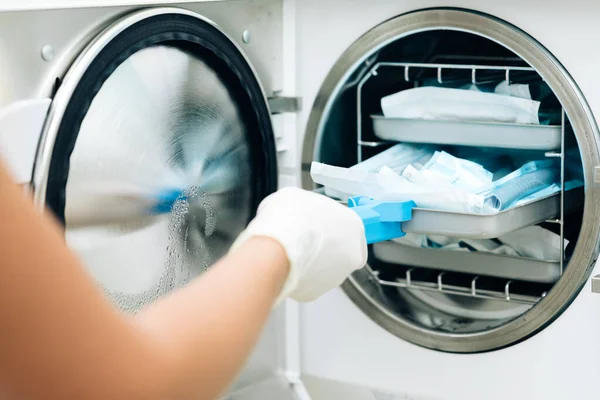 Hemşire işlemler için aletleri özel el işi kağıt torbalara koyuyor. Modern laboratuvar ekipmanları. Diş kliniğinde sterilizasyon, bakteriyel arıtma ve dezenfeksiyon.