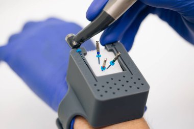 Eldivenli eldiven, dişçilik, sondalarla dolu endodontik kutular. Endodontik ekipman. Dişlerin kök kanallarında dişçilik yapmak için aletler. endodontik dosya yakın plan