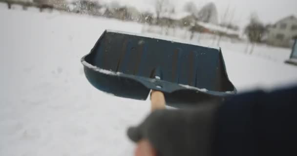 Muž s lopatou odstraňuje sníh. Úklid okolí domu po sněhové bouři. Osoba, která odhazuje sníh z příjezdové cesty. Obrovské sněhové závěje. Složitá situace ve městě po sněhové bouři — Stock video