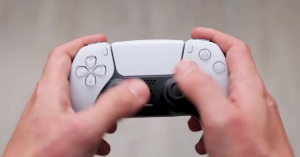 Lviv, Ucraina - 25 novembre 2020: PlayStation 5 Sony rivela PS5. Controllore a doppio senso. Uomo che tiene il joystick. — Video Stock