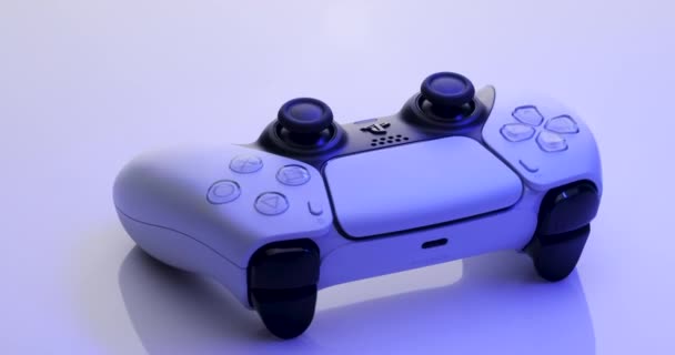 Kiev, Ucrania - 27 de febrero de 2021: Sony Playstation 5 Dualsense game controller. Nuevo producto de Sony, blanco inalámbrico PlayStation 5. La cámara gira en torno al controlador blanco con luz azul — Vídeos de Stock