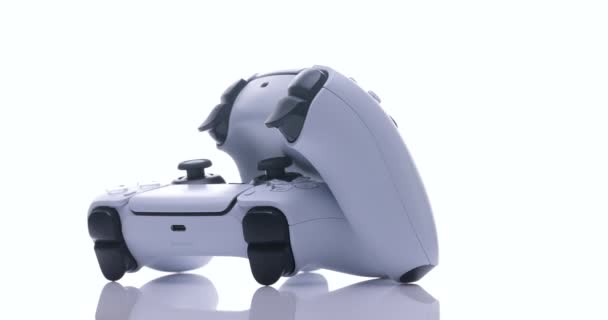 NEW YORK - February 27, 2021: Close up view of 2 controllers from new console with light. Two joysticks from Sony PlayStation 5 TV game console spin on a white background — Stock Video