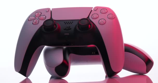 NUEVA YORK - 3 de marzo de 2021: Sony Playstation 5 Dualsense game controller. Nuevo producto de Sony, blanco inalámbrico PlayStation 5. La cámara gira alrededor del controlador blanco en luz roja. — Vídeos de Stock