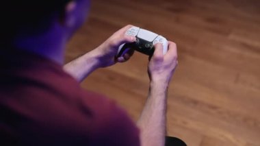 NEW YORK - 7 Mart 2021: Geniş ekran TV önünde oyun konsolunda oyun oynayan erkeklerin el çekimi. Adam Playstation 5 Dual Sense kontrolörüyle oynuyor. Renkli ışıklar.