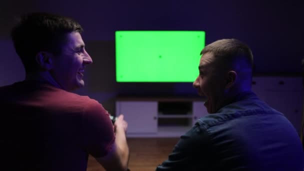 TV 앞 소파에 앉아서 콘솔에서 비디오 게임을 하는 행복 한 젊은이들. ( 영어 ) 프로페셔널 게임 선수권 대회 ( 영어 ) Professional Gamer Plays on Green Chroma Key Screen Personal TV — 비디오
