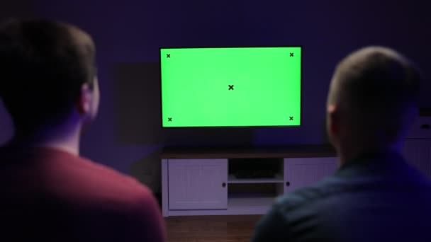 Powrót Shot of a Gamers Grając i wygrywając w grze wideo online na swojej konsoli z Green Chroma Key Screen Telewizor osobisty. Przytulny wieczór w domu — Wideo stockowe