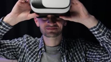 Modern 3D VR gözlükleri kullanan bir adam. Öğrenci VR gözlüğü kullanıyor. Sanal gerçeklik kulaklığı takan yakışıklı bir adam. Artırılmış Gerçeklik