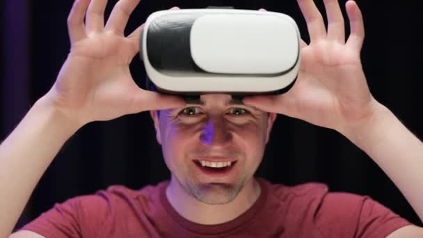 Młody hipster używający zestawu słuchawkowego VR do oglądania filmu 360 podczas siedzenia na kanapie w domu w salonie. Blisko człowieka za pomocą nowoczesnych okularów 3D vr. Rozszerzona rzeczywistość — Wideo stockowe