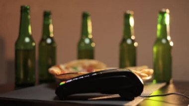 Elektronik ödeme makinesinden ya da kart okuyucudan ödemeyi telefonla yapın. Nakitsiz cüzdanda e-para. Erkek müşteri, erkek satıcının terminalinde ya da kahve dükkanında ya da gıda süpermarketinde çalışıyor.