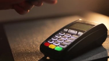 Akıllı telefon kartı başvurusuyla NFC teknolojisiyle ödeme yapan adam. Alışveriş merkezindeki bankamatik cüzdanında yakın plan yakışıklı bir erkek..