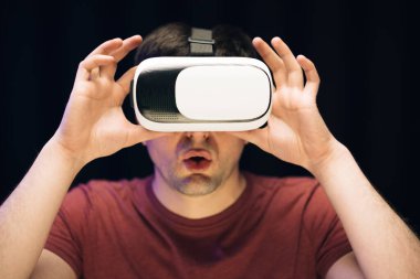 Sanal gerçeklik kulaklığı takan yakışıklı bir adam. Artırılmış Gerçeklik. Modern 3D VR gözlükleri kullanan bir adam. Öğrenci VR gözlüğü kullanıyor