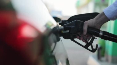 Benzin istasyonunda yakıt ikmali yapmak. El ele tutuşup işlemi kaydediyoruz. Yakıt, benzin istasyonu, benzin fiyatları kavramı. Benzin, benzin, yakıt, petrol konsepti. İstasyon pompasında benzinle dolduruyorum.