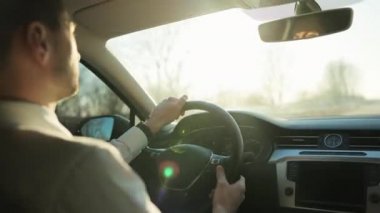 Parlak manzaraya doğru araba süren adam yol boyunca parlayan güneş zevki. Erkek El direksiyonda. Sunset 'te araba süren adam. Şık erkek sürücü otomobille seyahat ediyor.