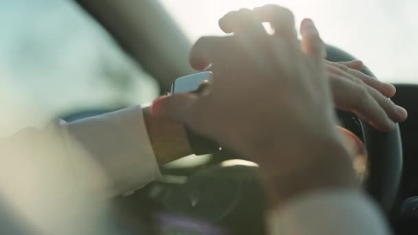 Primo piano mani maschili utilizzando moderno orologio intelligente all'interno dell'auto. Vita da uomo d'affari. Man watch notifica. Mano maschile con un orologio intelligente tiene il volante. — Video Stock