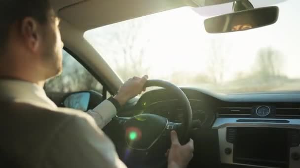 Muž řízení auto směrem k jasné scenérie slunce potěšení svítí nad silnicí. Mužská ruka na volantu. Muž řídí auto při západu slunce. Elegantní muž řidič cestování automobilem — Stock video