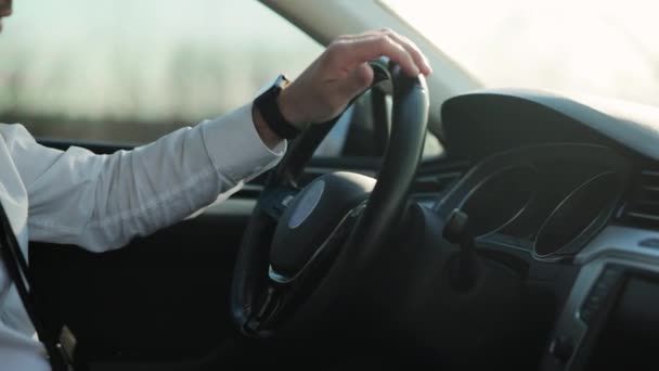 商人在日落时开车.男人看通知。驾驶人士手握方向盘，配戴现代智能手表装置 — 图库视频影像