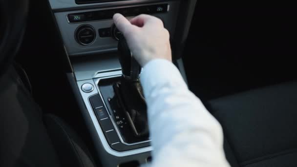 Drivers adm incluye el modo de conducción en la palanca de cambios transmisión automática de las piezas interiores del coche de lujo. Hombre de negocios en traje de la mano de control de la transmisión stick shift. — Vídeos de Stock